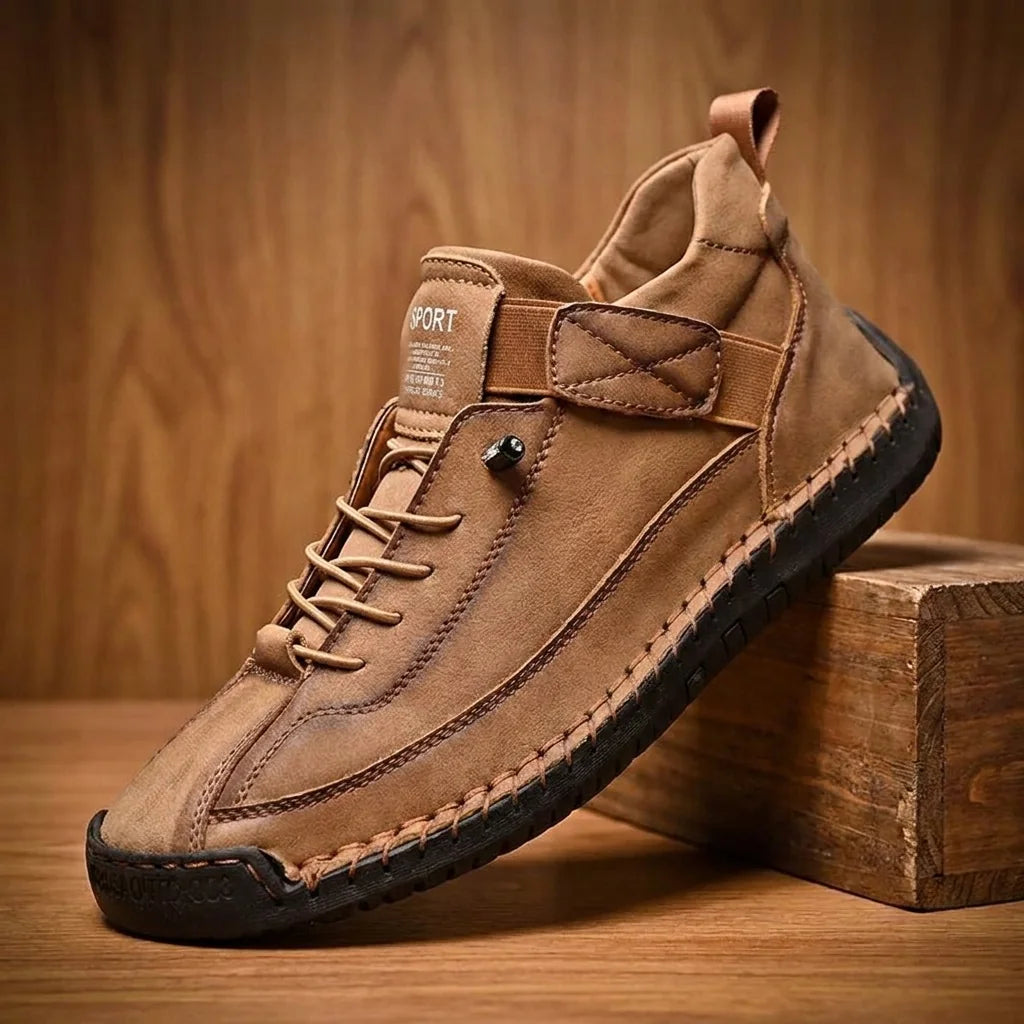 Brown slip-on casual shoe with hand-stitched sides on warm wood