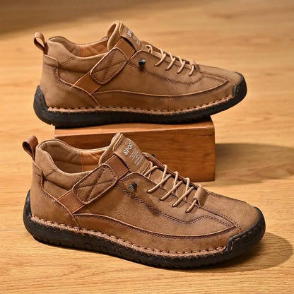 Pair of brown hand-stitched slip-on casual shoes on warm wood