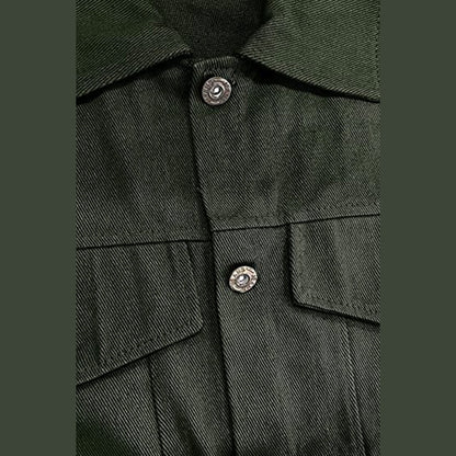 Close view of a metal button and a flap pocket on the green jacket