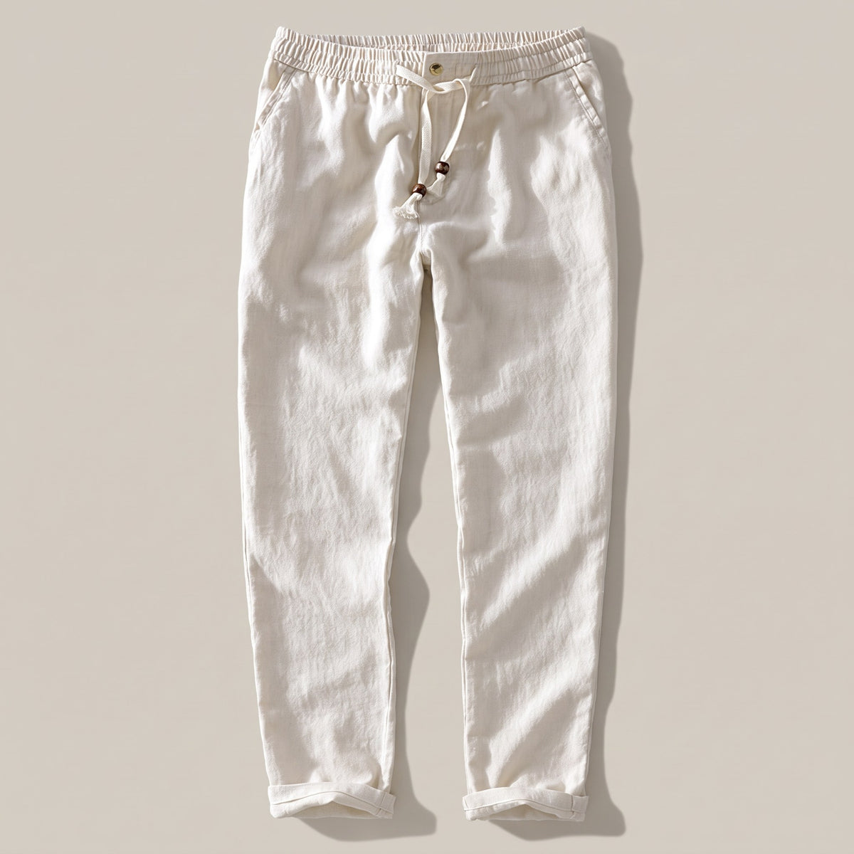 Men's cream drawstring pants with an elastic waist and rolled hem, front view