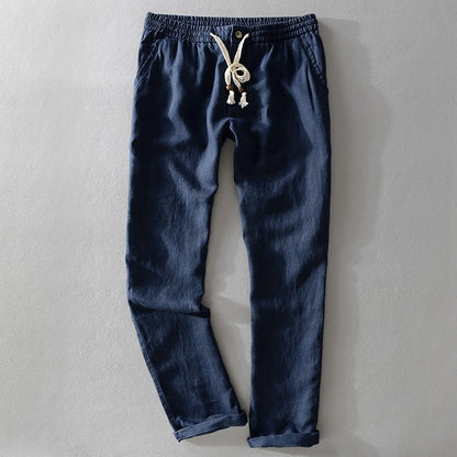 Dark blue drawstring pants laid flat with a tasselled cord