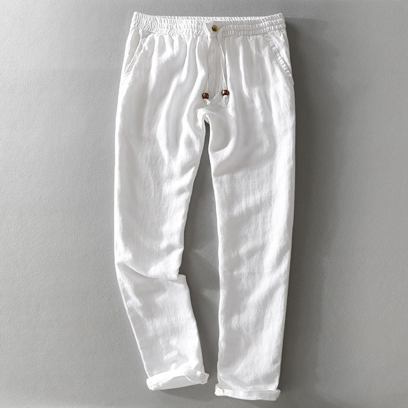White drawstring pants laid flat with a rolled hem