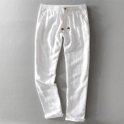 White drawstring pants laid flat with a rolled hem