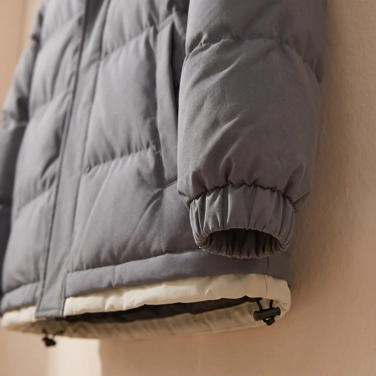 Men's hooded puffer jacket elastic cuff and hem toggle close-up