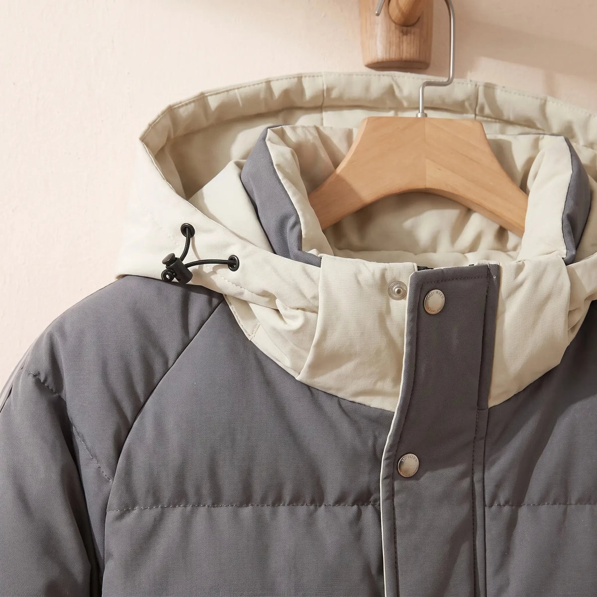 Men's hooded puffer jacket drawcord hood and snap front close-up