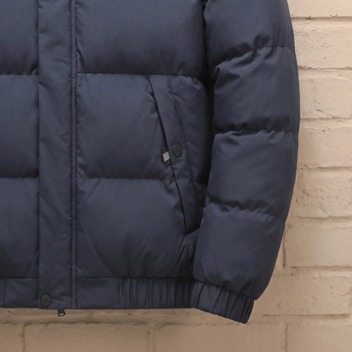 Men's stand-collar puffer jacket zip pocket and rib cuff close-up