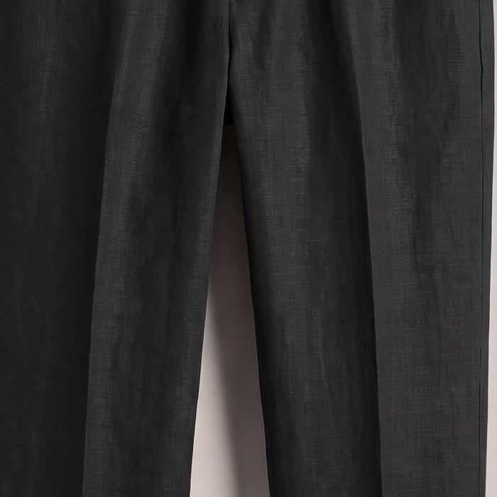 Close view of the woven fabric surface and front crease on the black trousers