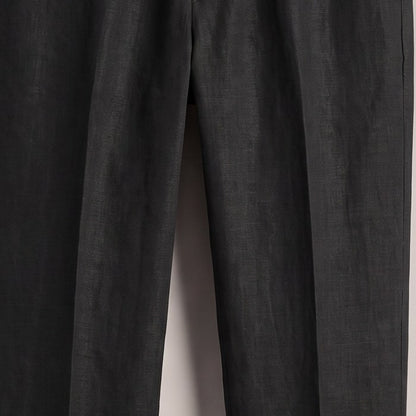 Close view of the woven fabric surface and front crease on the black trousers