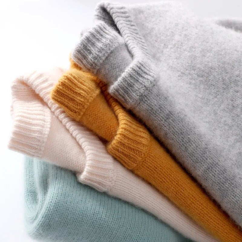 Stack of folded knit sweaters showing the ribbed cuffs