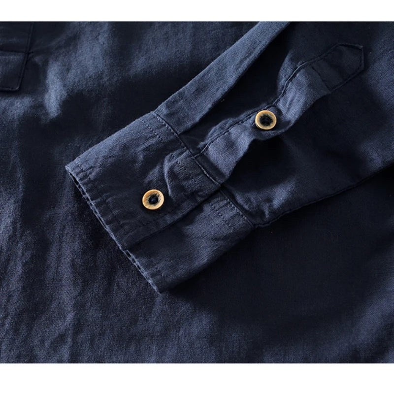Close view of the cuff and metal button on the navy shirt