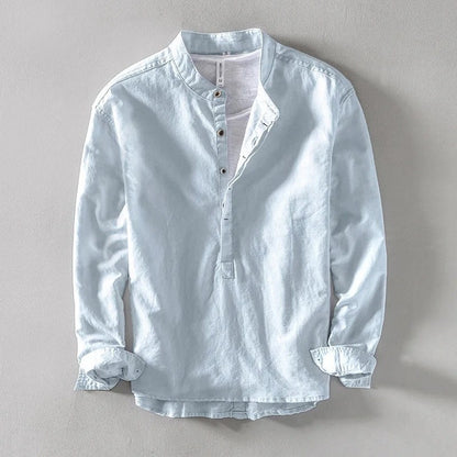 Light blue band-collar shirt laid flat with rolled cuffs