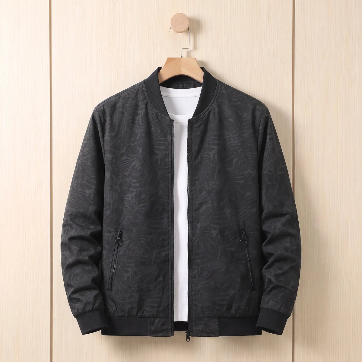 Black leaf print men's bomber jacket on a hanger