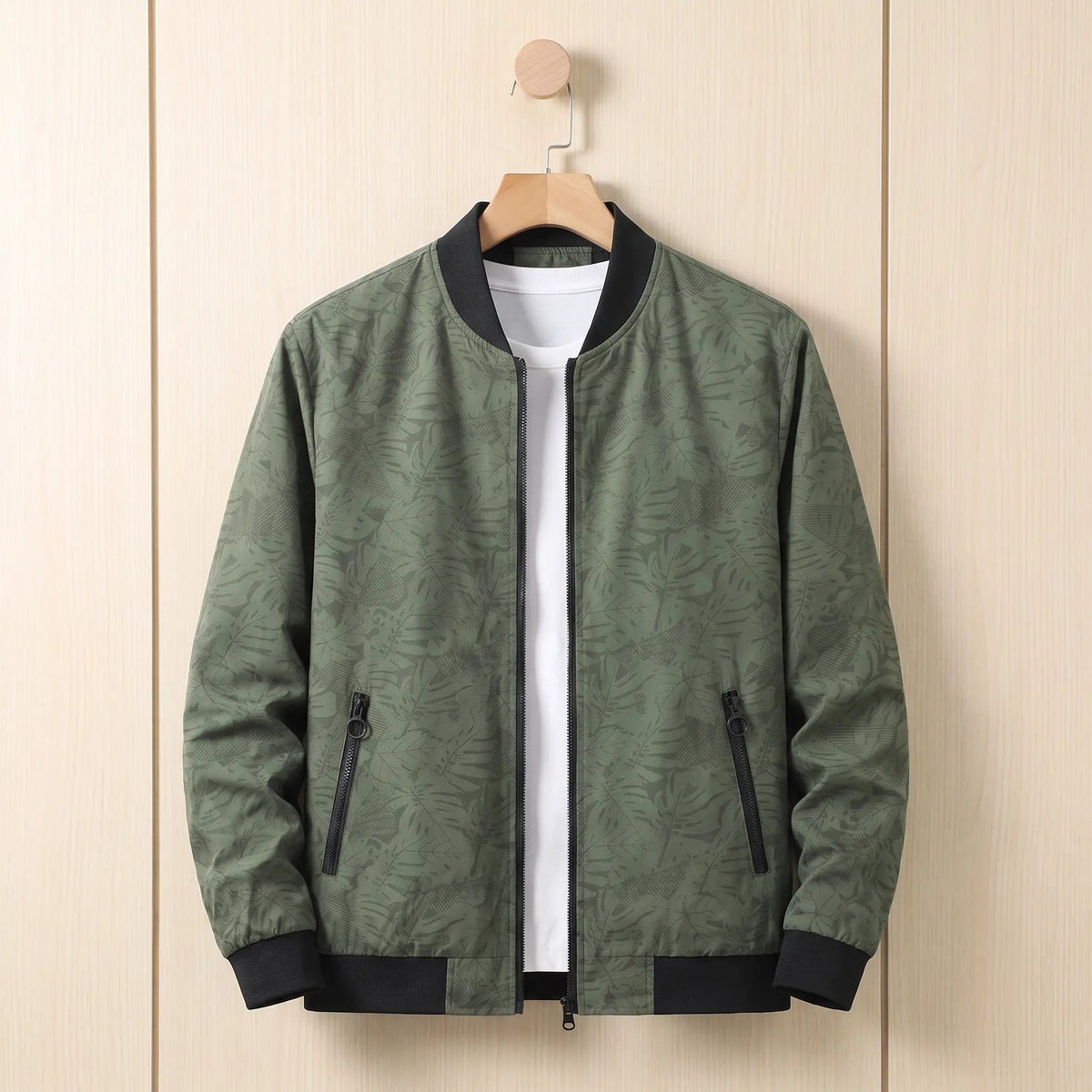 Green leaf print men's bomber jacket on a hanger