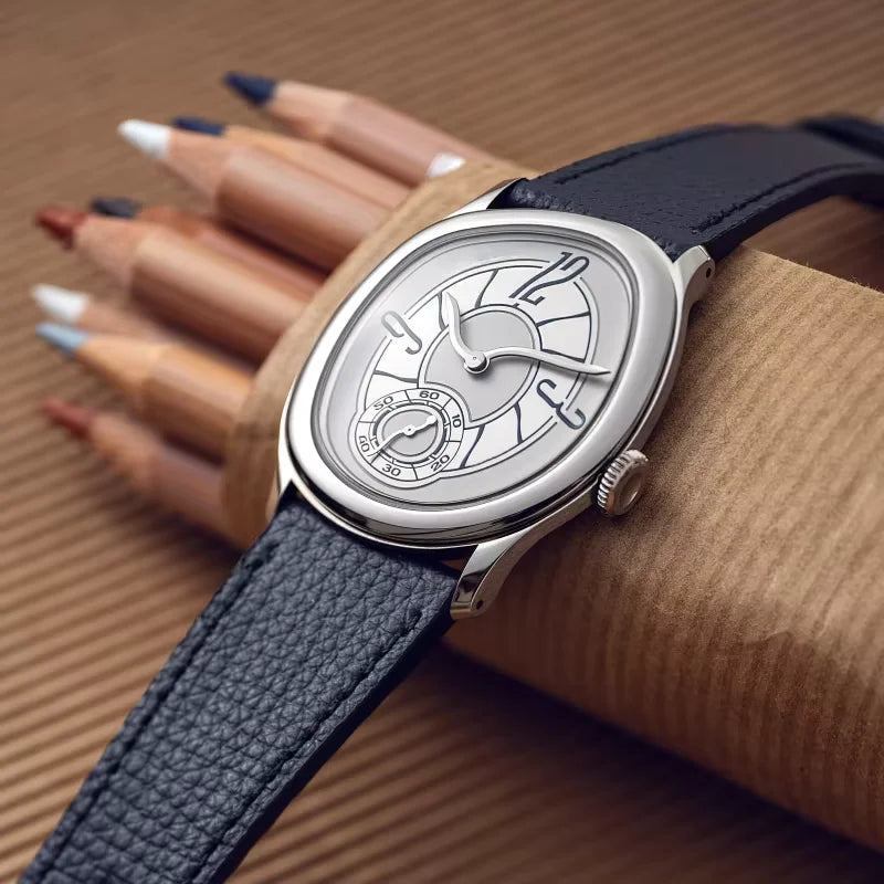 Harcourt silver-toned oval watch resting on a hand beside pencils