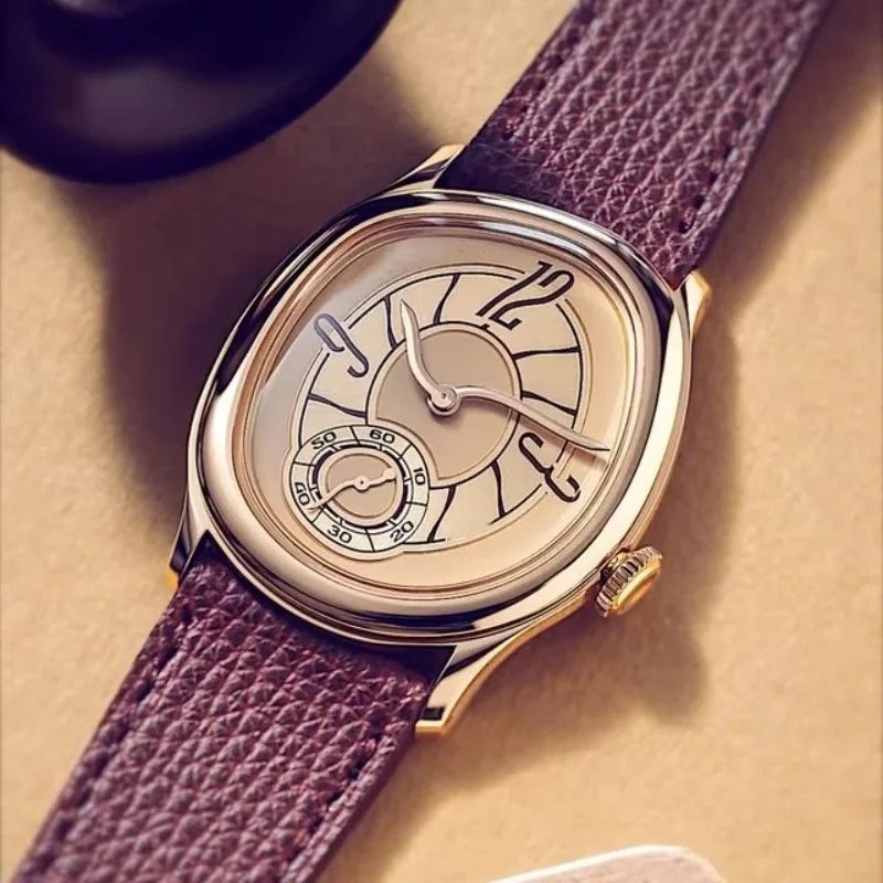 Harcourt gold-toned oval watch lying flat showing the layered dial