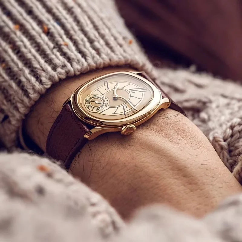 Harcourt gold-toned oval watch with a knitted sweater sleeve