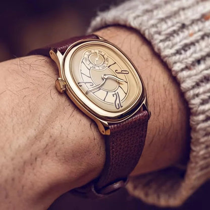 Harcourt gold-toned oval watch on a wrist with a burgundy strap