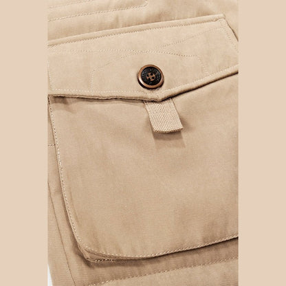 Close view of a flap pocket with a metal button on the khaki parka