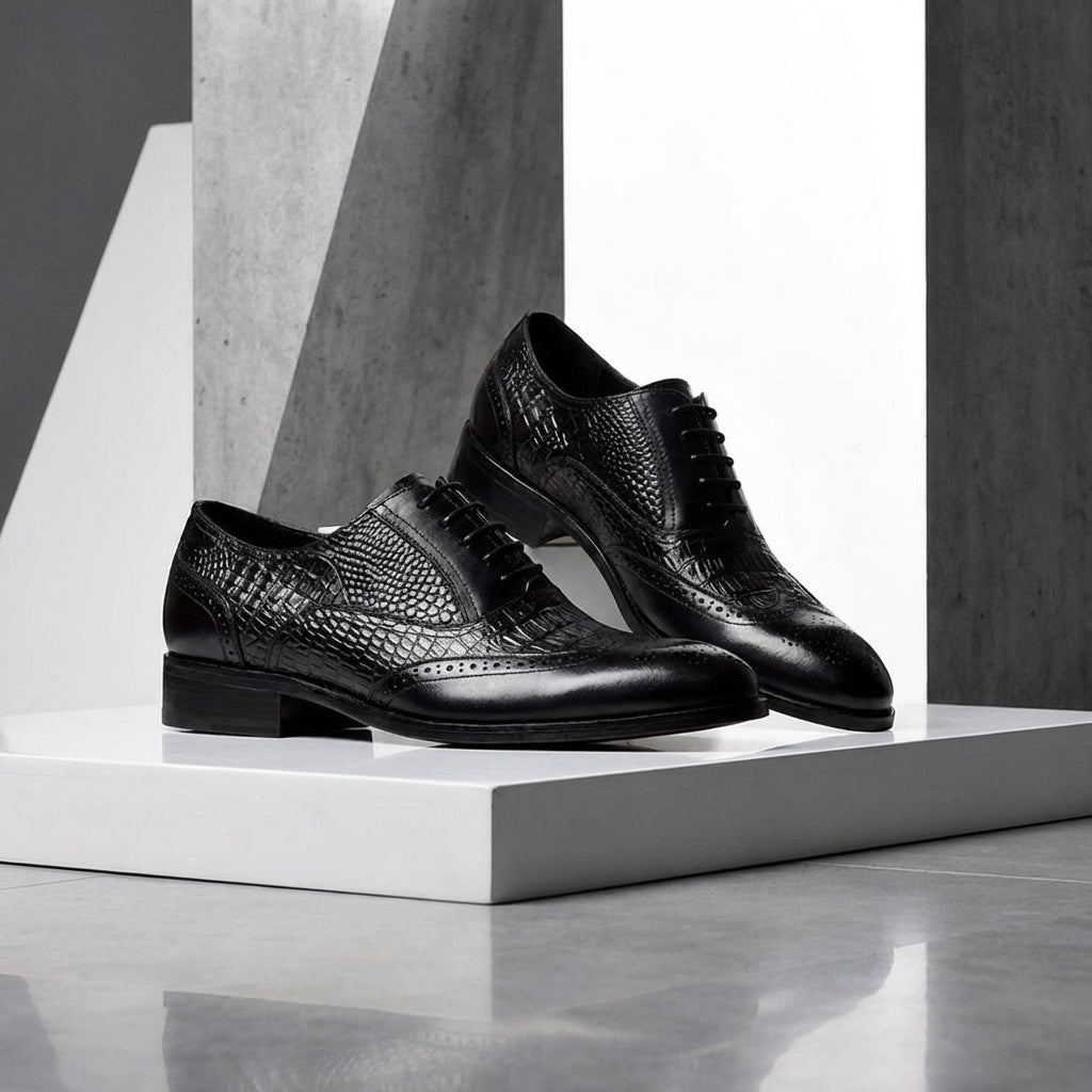 Pair of black Kendrick brogue oxfords on a white block
