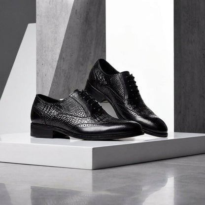 Pair of black Kendrick brogue oxfords on a white block