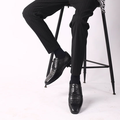 Black Kendrick brogue oxfords worn while seated on a stool