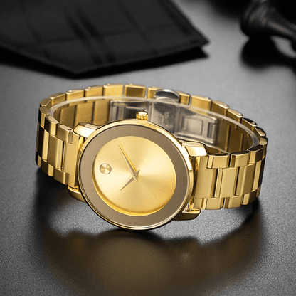 Gold Larkin watch lying on a dark surface with the bracelet clasp in view