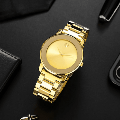 Gold Larkin watch standing on a desk beside a phone and pen