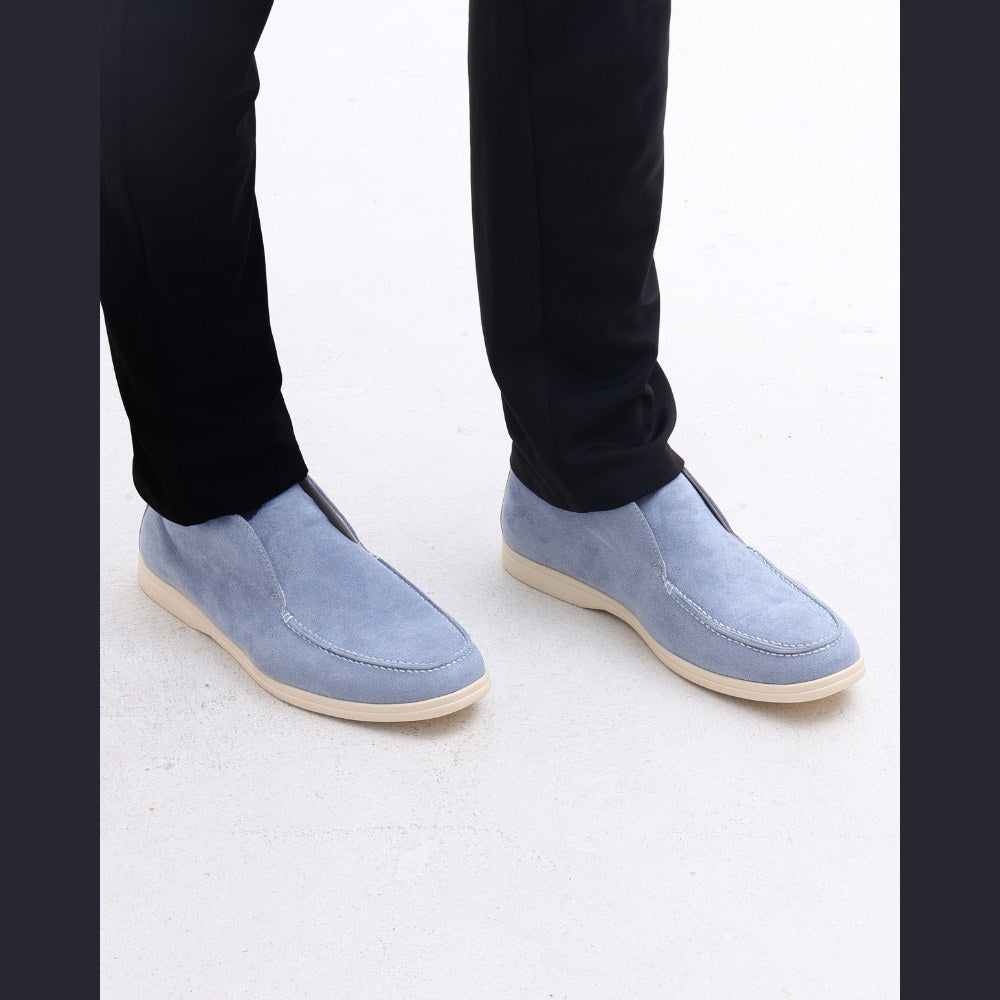 Front view of the pale blue high-top suede slip-ons worn with black trousers