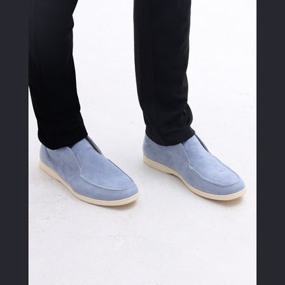 Front view of the pale blue high-top suede slip-ons worn with black trousers