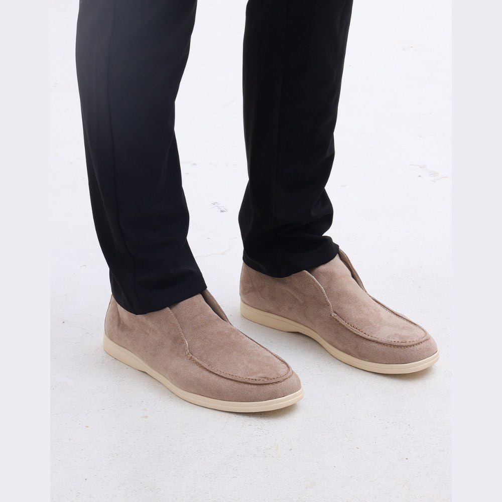 Front view of the taupe high-top suede slip-ons worn with black trousers