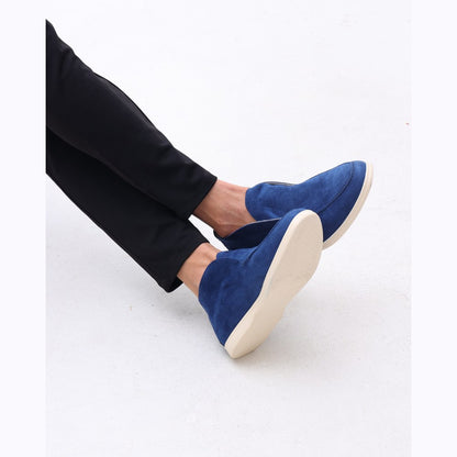 Lower-leg view of the high-top suede slip-ons worn with black trousers, face not shown