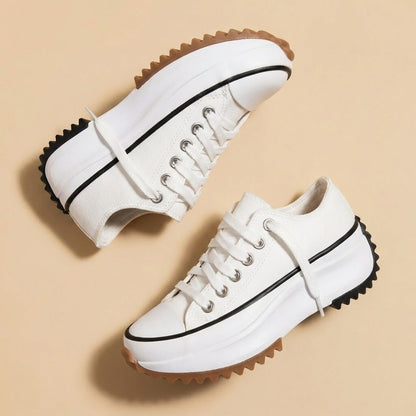 White platform sneakers with a white sole and black stripe, seen from above