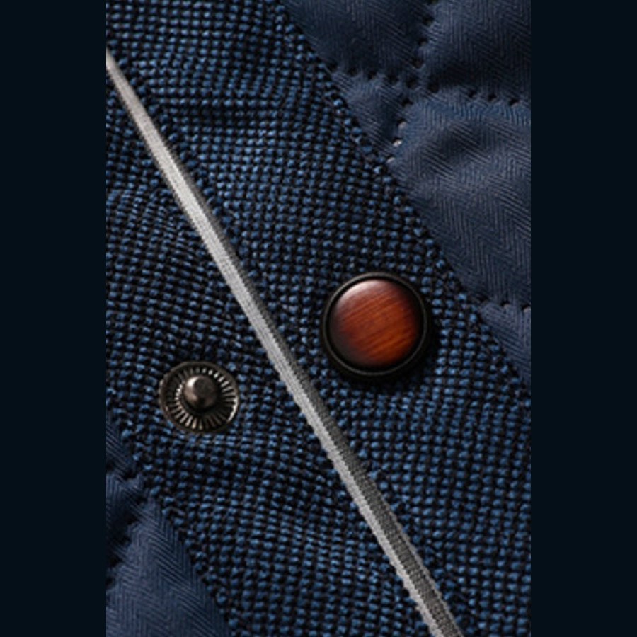 Close view of a wooden-look button and a snap on the quilted front