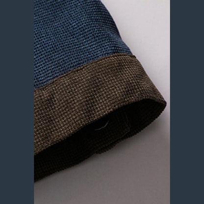 Close view of the brown ribbed cuff edge on a blue sleeve