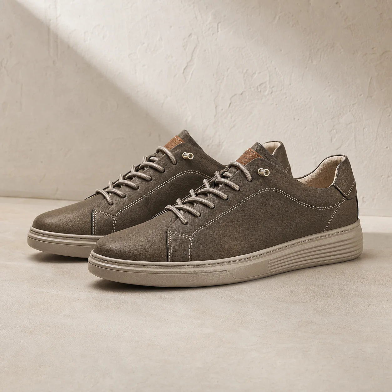 Torino Leather Trainers in Brown on clean studio stone
