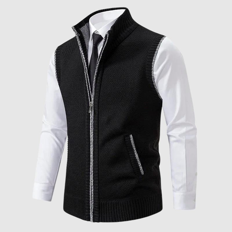 Black knit vest worn over a white shirt and tie, zipped up